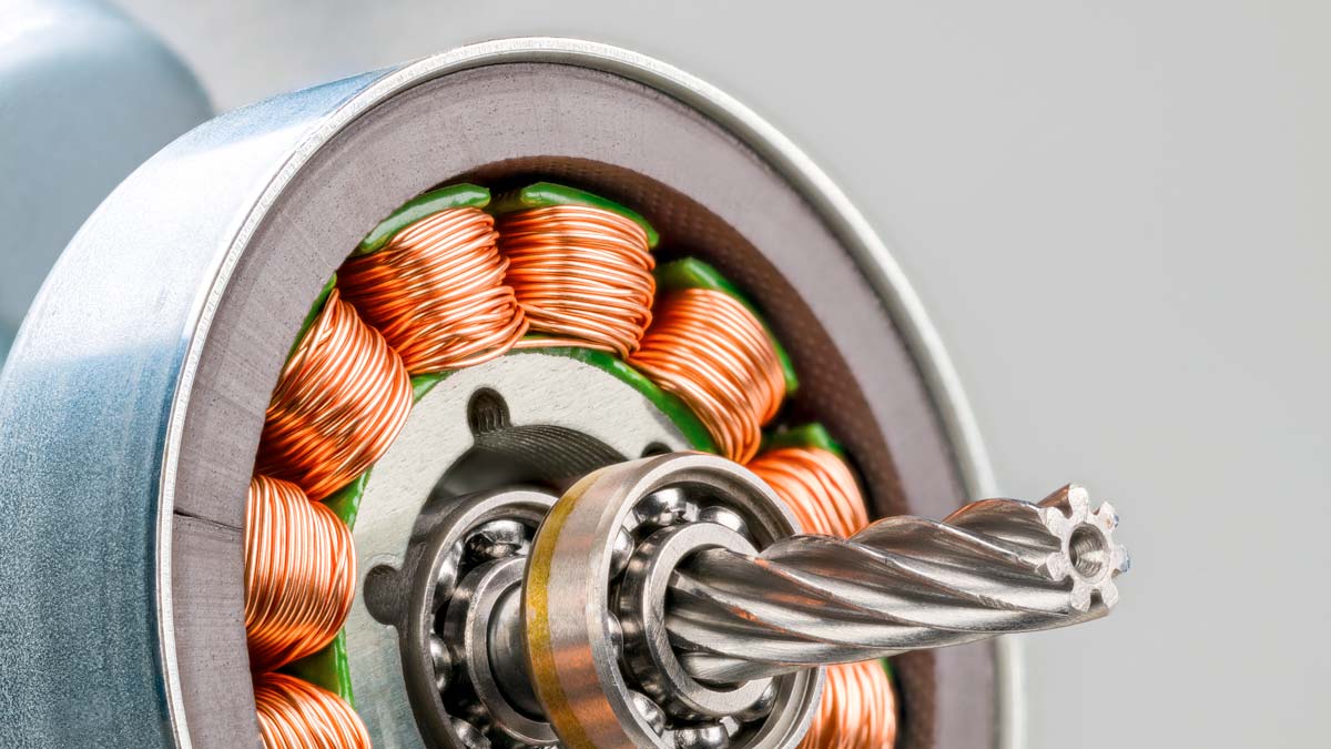 Kupferdrahtwicklung auf elektromagnetischen Spulen mit Metallblechen im Inneren einer Stahlbuchse eines Elektromotors